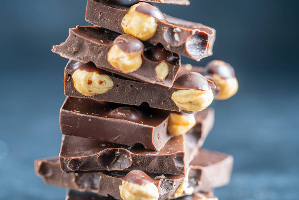 Pile chocolate with nuts on the gray background, close up - Фото, зображення