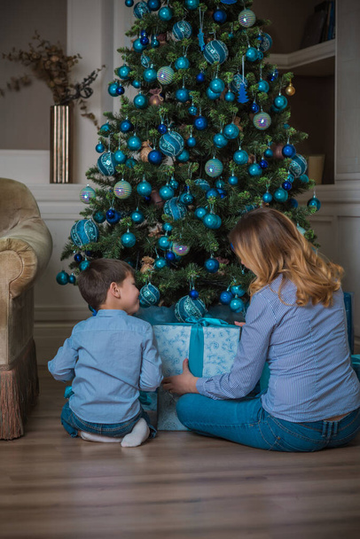 Scena rodzinna mama i dziecko, czas świąt. Miła mama i mały chłopiec w czasie Bożego Narodzenia, dzieci i rodzice styl życia - Zdjęcie, obraz