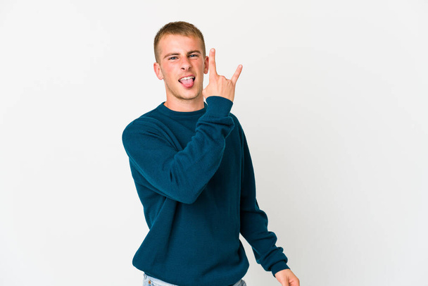 Νεαρός καυκάσιος όμορφος άνδρας δείχνει ροκ χειρονομία με τα δάχτυλα - Φωτογραφία, εικόνα