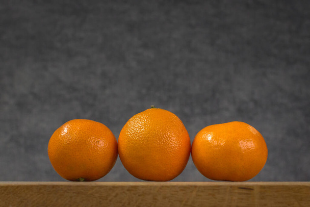 Mandarin on a gray background. Orange citrus fruit. Winter vitamins. New Year's tradition. Variety Clementine. Ripe tangerines in a peel. Organic food. Healthy eating. - Foto, imagen