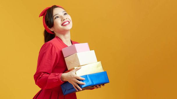 Piękna młoda kobieta trzyma wiele pudełek z prezentów świątecznych i noworocznych - Zdjęcie, obraz