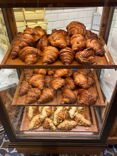 Croissants for Sale on Glass and Wooden Showcase Display at Bakery Shop. Ready to Eat and Serve. - Foto, afbeelding