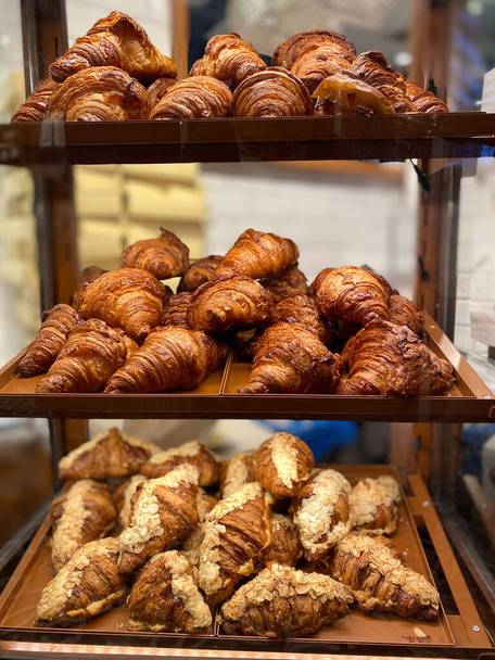 Croissants for Sale on Glass and Wooden Showcase Display at Bakery Shop. Ready to Eat and Serve. - Fotoğraf, Görsel