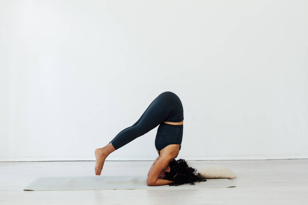 Beautiful brunette woman yoga asana gymnastics fitness stands on her head - Foto, Imagem