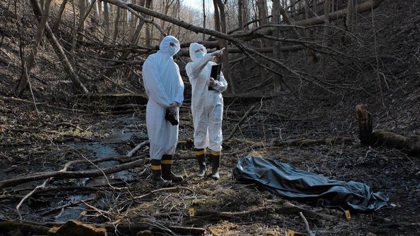 Detectives are collecting evidence in a crime scene. Forensic specialists are making expertise. Professional police investigation in a forest. - Foto, immagini