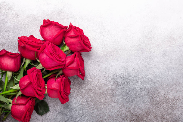 Valentines day greeting card with bouquet of red roses on stone background. Top view. Copy space - Image - Фото, зображення