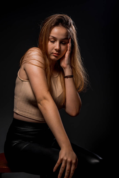 Stylish fashion girl posing in trendy clothes against dark background - Fotó, kép