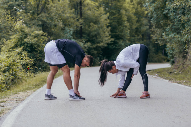 Atletas masculinos y femeninos preparándose para un maratón, correr, hacer ejercicio. concepto de estilo de vida saludable. - Foto, imagen