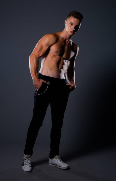 Portrait of a handsome male model posing in trendy black jeans - Photo, Image