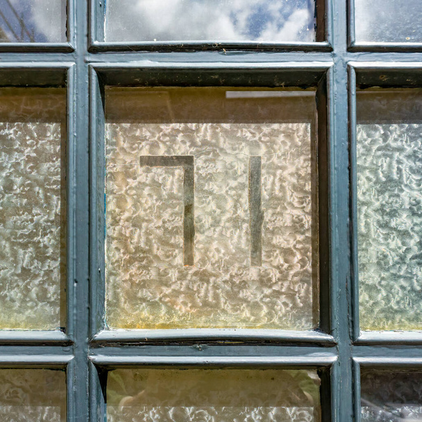 71. ev, pencereye yapıştırılmış yapışkan filmden kesilmiş. - Fotoğraf, Görsel