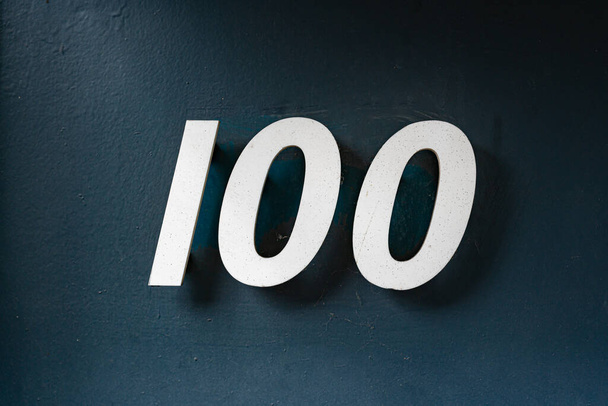 100-as számú ház (100). Külön betű a vakolt falon - Fotó, kép