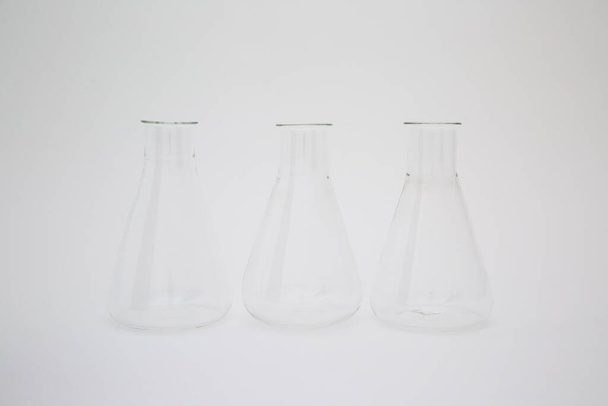 Three scientific laboratory glass erlenmeyer flask isolated on white background - Photo, image