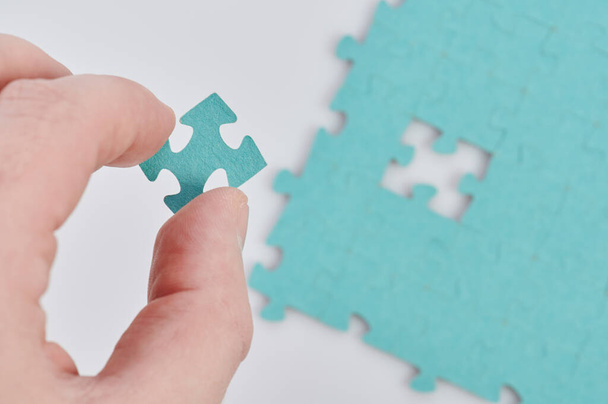 Inserting missing puzzle piece. Hand join jigsaw - Photo, Image