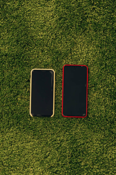 Two Generations of Smartphones on Grass - Zdjęcie, obraz