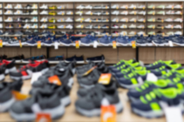 large shoe store with long shelves filled with shoes, blurred and defocused - Foto, immagini