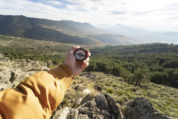 Hand hält einen Kompass auf einem Berg, Konzept des Reisens. - Foto, Bild