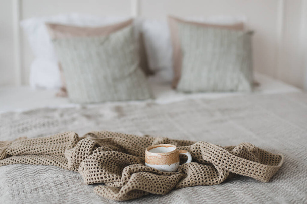 Cup of coffee with warm plaid. Breakfast in bed. White stylish cozy bedroom. Hygge concept. Copy space. Flat lay, top view. - Foto, immagini
