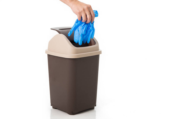 hand throws medical glove into the trash. - Photo, Image