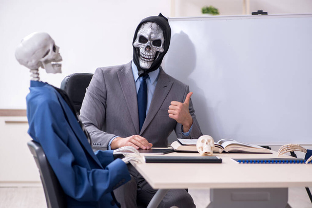 Grappige zakelijke ontmoeting met duivel en skeletten - Foto, afbeelding