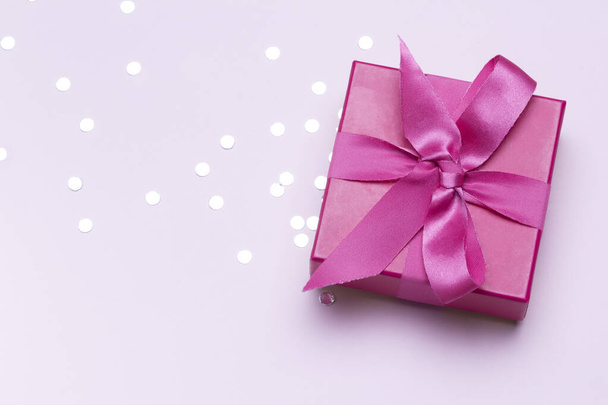 Розовый подарок с серебряными конфетти. Копирование места для рекламы. Концепция празднования и поздравления. - Фото, изображение