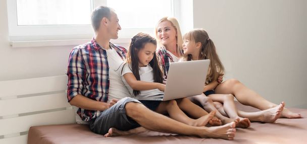 Familia animada comprar en línea acostado en la cama en casa - Foto, imagen