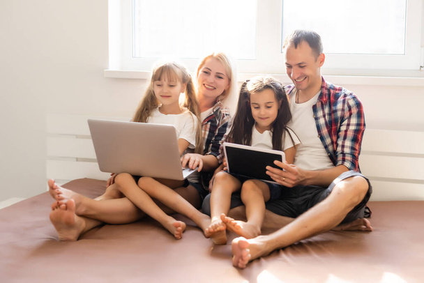Animated family buying online lying down on bed at home - Foto, immagini