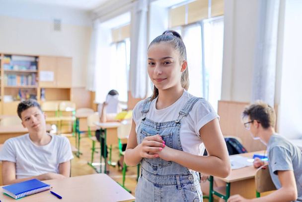 Teenage student taking exam, classroom with study students background - Zdjęcie, obraz