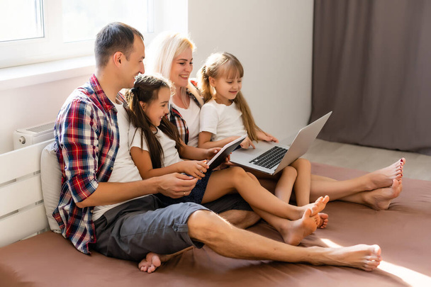 Animowana rodzina kupuje online leżąc na łóżku w domu - Zdjęcie, obraz