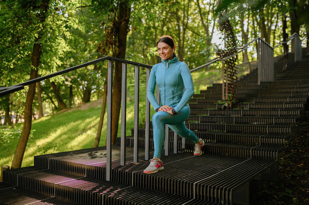 Morgentraining auf der Treppe im Park, sportliche Frau. Läuferin treibt Sport an sonnigen Tagen, gesunder Lebensstil, Mädchen beim Outdoor-Training - Foto, Bild