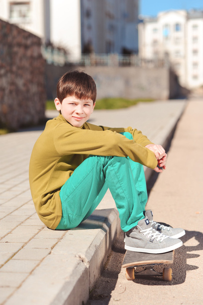 хлопчик сидить на скейтборді
 - Фото, зображення