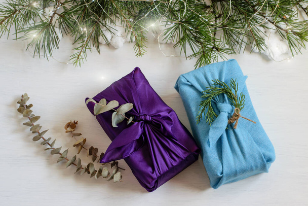 Різдвяні подарункові коробки ручної роботи, загорнуті в текстильну тканину в японському традиційному стилі фурошікі. Гарний дизайн вітальних листівок, нульові відходи та концепції
.  - Фото, зображення