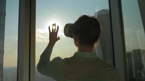 Movimento lento: silhueta mulher usando fone de ouvido VR contra a janela do arranha-céu - Filmagem, Vídeo