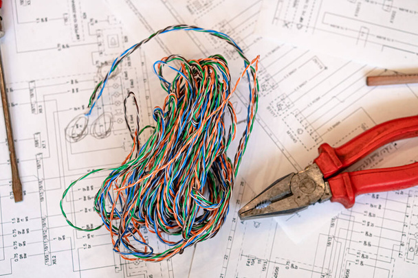 Различные электрические инструменты и провода на бумажной диаграмме, композиция о домашней электронике - Фото, изображение