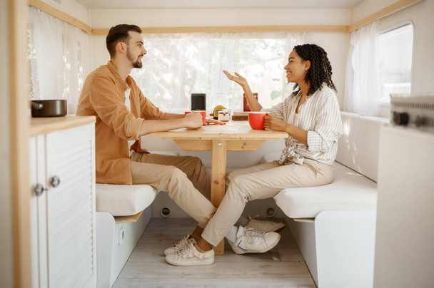 Amor pareja desayunando en rv, acampando en un remolque. Hombre y mujer viaja en furgoneta, vacaciones románticas en autocaravana, campistas distracciones en camping-coche - Foto, Imagen