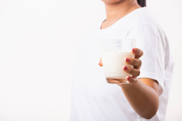 Asian portrait of happy young Asian beauty woman use hands hold drink white milk from a glass, studio shot isolated on white background, Food healthy care concept - 写真・画像