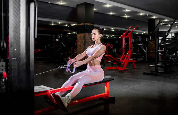 mujer joven en ropa deportiva haciendo ejercicios en el gimnasio - Foto, imagen