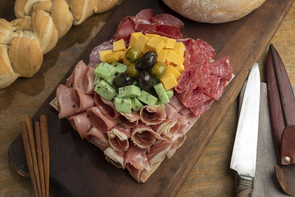 A high angle shot of a gourmet delicious charcuterie board with different meats and cheeses - Foto, afbeelding