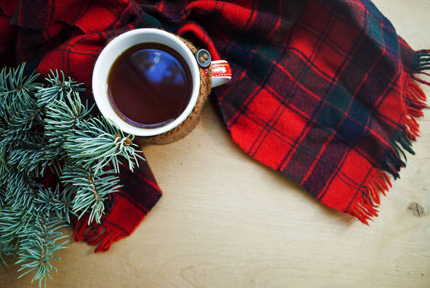 Fond d'hiver avec une branche d'arbre de Noël.Une tasse de thé chaud au citron, vêtu d'une écharpe d'hiver chaude tricotée sur un fond en bois. - Photo, image