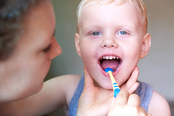 Mamma insegna e aiuta suo figlio di tre anni a lavarsi i denti, primo piano. - Foto, immagini