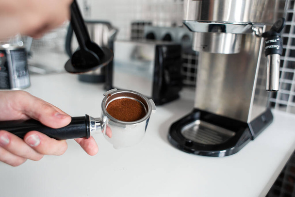 Guy prepare delicious aromatic coffee in a coffee machine. A simple way to make coffee. - Foto, Imagen