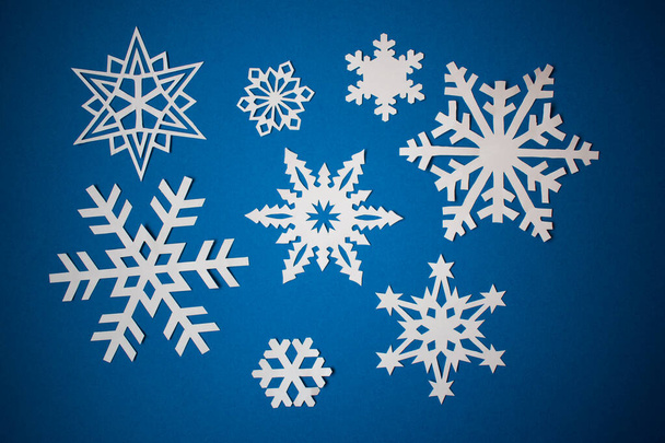 Διάφορες νιφάδες χιονιού χαρτιού σε μπλε φόντο - Φωτογραφία, εικόνα