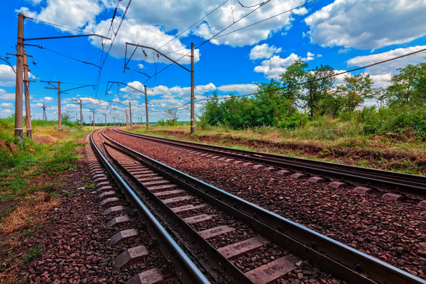 Brillante paisaje de verano del ferrocarril durante el día. Bajo el cielo azul nublado. - Foto, Imagen