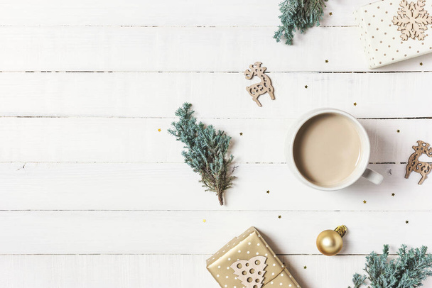 Noel kompozisyonu. Bir fincan kahve, yemyeşil ağaç, beyaz ahşap arka planda hediyeler ve süsler. Kış, tatil konsepti. Düz konum, üst görünüm, kopyalama alanı. - Fotoğraf, Görsel