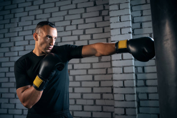athletic sport man boxer training with punching bag or exercising in gym - Photo, Image