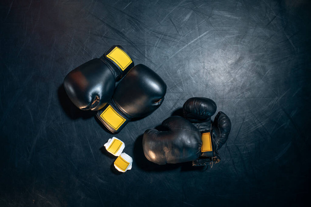 top view of boxing gloves, helmet and bandage tape on black background - Foto, Imagen