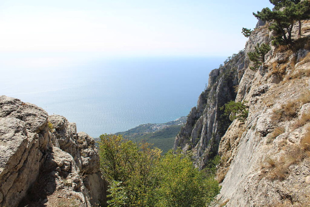 prachtig uitzicht van AI-Petri berg op Zwarte zee in de herfst in de Krim / foto landschap van de bergen en zee in de Krim. Bovenkant van de berg Al-Petri. uitzicht op de Zwarte zee vanaf een hoogte. Het water is blauw. Zonnig weer in de herfst. - Foto, afbeelding