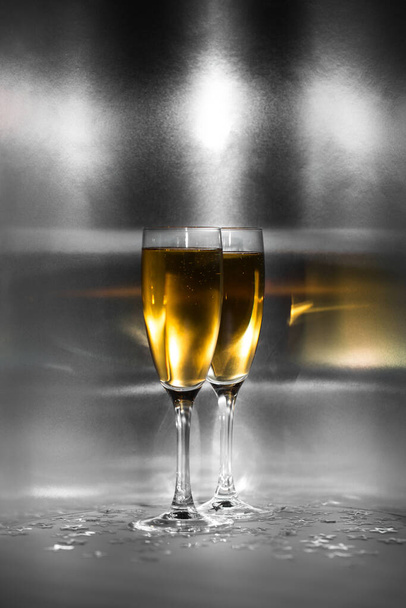 Two glasses with golden champagne on a sparkling background. - Valokuva, kuva