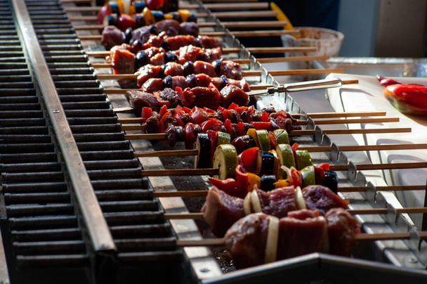 Many barbecue sticks with meat and vegetables on barbecue grill  - Photo, Image