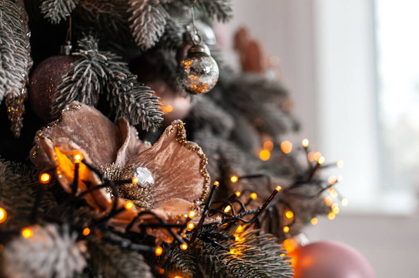 Nahaufnahme des geschmückten Weihnachtsbaums mit Spielzeug und Lichtern  - Foto, Bild