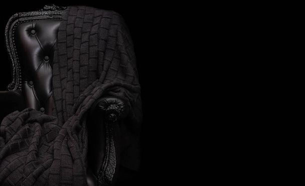Oude stijl zwarte lederen stoel en een prachtige gebreide deken erop, zwart geïsoleerd met placholder  - Foto, afbeelding